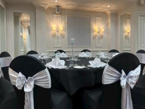 een eetkamer met een tafel met stoelen en bogen bij The Aberdeen Dyce Hotel in Dyce