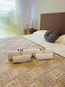 Una cama con cuatro almohadas blancas encima. en Chito House en Buenos Aires