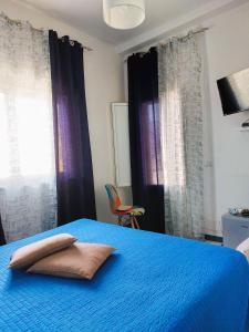 1 dormitorio con 1 cama azul y 2 almohadas en La casa dei 4 venti, en Ponza