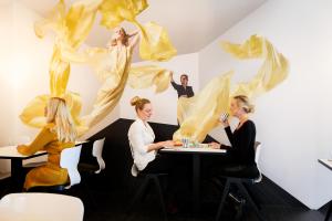 un grupo de personas sentadas en una mesa con una pintura en Design Hotel Modez en Arnhem