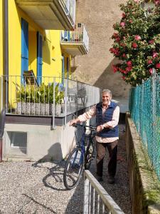 een oudere man staat naast een fiets bij Dolceresio Lugano Lake B&B in Brusino Arsizio