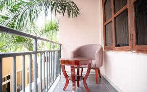 een tafel en een stoel op een balkon bij Comfort Inn Mbezi Beach in Dar es Salaam