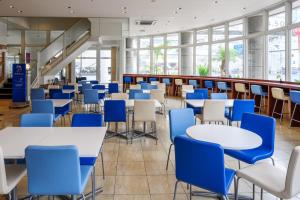 una cafetería con mesas y sillas azules en Toyoko Inn Okinawa Naha Asahibashi Ekimae, en Naha