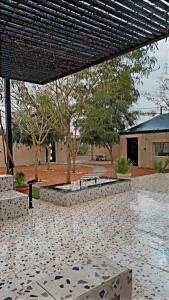 a park with benches and trees and a building at شاليهات ليليان in Riyadh Al Khabra