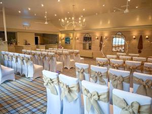 - une rangée de chaises dans une salle de banquet avec des tables dans l'établissement Caley, à Hunstanton