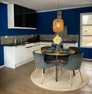 a kitchen with a table and chairs and blue walls at BB Grindhuset in Larvik