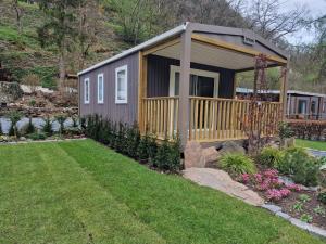 una casa pequeña con terraza en un patio en Chalet Hockslee en Goebelsmuhle