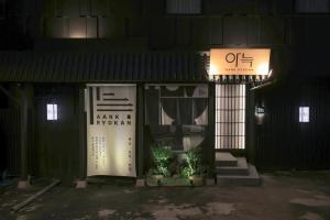 an entrance to a building at night with a sign at Aank Ryokan Hotel Paju in Paju