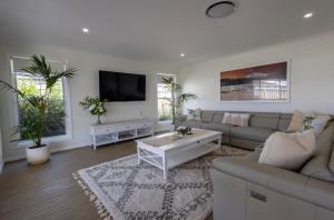 un soggiorno con divano e TV di Luxury on Lesmurdie - Close to Zoo & Golf Club a Dubbo