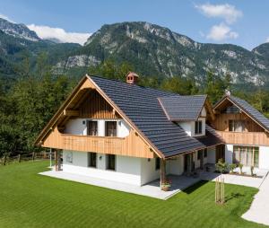 uma imagem de uma casa com montanhas ao fundo em PRIVILLAGE Stare - B&B em Bohinj