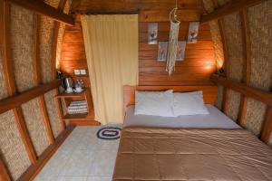 - une chambre avec un lit dans une cabane en bois dans l'établissement Volcano Cabin Batur RedPartner, à Baturaja