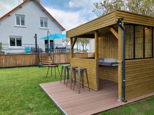 una terraza de madera con barra y taburetes en Gîte Le Berceau du Marin 4 chambres terrasse & spa Redon centre 300m en Saint-Nicolas-de-Redon