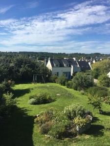 una casa en una colina con césped y un parque infantil en Maison de pêcheur proche plage et activités en Crozon