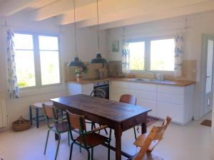 cocina con mesa de madera y sillas en Maison de pêcheur proche plage et activités en Crozon