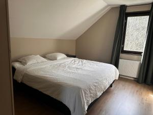 een slaapkamer met een bed met witte lakens en een raam bij Family Friendly Villa Close To Ullared, 3bedrooms in Älvsered