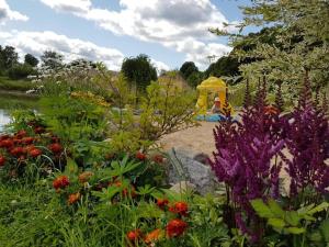 un jardín con flores de colores y una estructura de juegos en Liepu Residence en Olayne