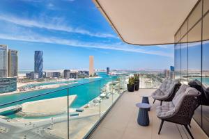 a balcony with two chairs and a view of the city at Conrad Bahrain Financial Harbour in Manama