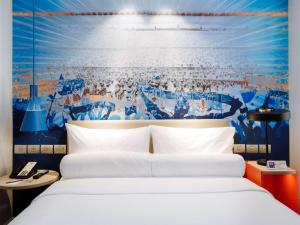 Un pat sau paturi într-o cameră la ibis Styles Manila Araneta City