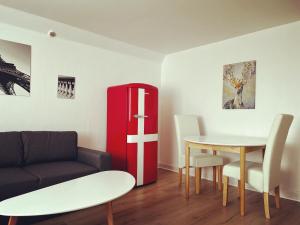 a living room with a table and a red refrigerator at Cozy Holeby Pet-Friendly Villa - Puttgarden&Femern in Holeby