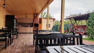 un patio con mesas y sillas de madera y una cocina. en Casa SOL, en Turda