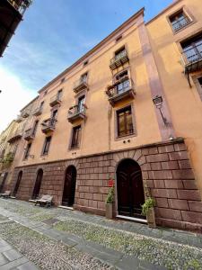 un gran edificio de ladrillo con ventanas y puertas. en Sardinian Gallery Corso en Bosa