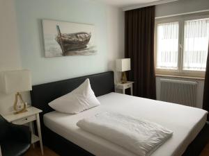 Un dormitorio con una cama con una almohada blanca. en Hotel Berg en Seekirchen Markt