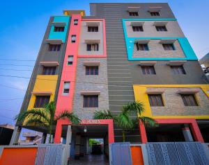 un edificio alto con colores en S V IDEAL HOMESTAY -2BHK SERVICE APARTMENTS-AC Bedrooms, Premium Amities, 2KM to Tiruchanoor Padmavathi Temple , 6KM to Alipiri, 24 HOURS Service BOYS Available, en Tirupati