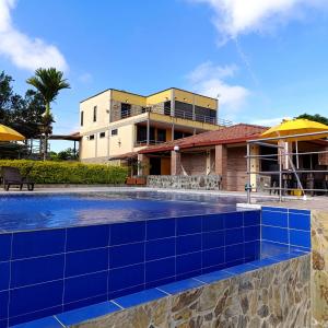 uma piscina em frente a um edifício em Hotel Campestre Los Mangos em Quimbaya