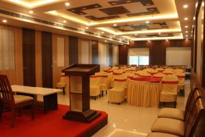 una sala de conferencias con mesas y sillas y un podio en Sea Resort !! New Digha, en Digha