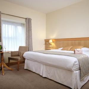 A bed or beds in a room at Mahon's Hotel