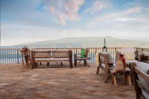 Ngorongoro Lodge member of Meliá Collection في نجورونجورو: سطح مع مقاعد وطاولة وكراسي