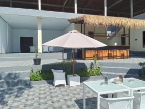 a patio with an umbrella and tables and chairs at Scuba Tribe Bali dive-resort in Tulamben