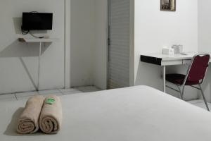 una camera con letto, scrivania e sedia di Cozy Home 2 RedPartner a Manado