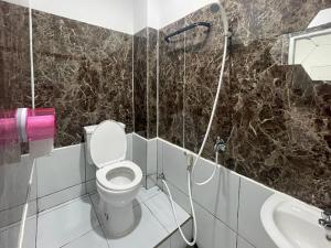 bagno con servizi igienici e lavandino di Cozy Home 2 RedPartner a Manado