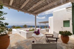 un patio con bañera, sillas y mesa. en Fos Apartments Mykonos, en Agios Ioannis Mykonos