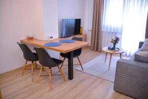 - un salon avec une table et des chaises en bois dans l'établissement Apartman Mona, à Teslić