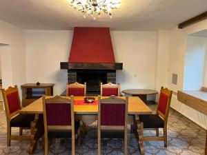 comedor con mesa y chimenea en Pension Blockheidehof 