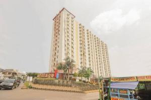 un grand bâtiment blanc avec des voitures garées devant lui dans l'établissement Cibubur Village Apartment by Sang Living, à Cibubur