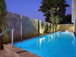 uma piscina em frente a uma parede em Swiss-Belinn Simatupang em Jacarta