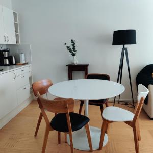 uma cozinha com uma mesa branca e cadeiras e uma mesa em Studio Linnankatu 25 em Savonlinna