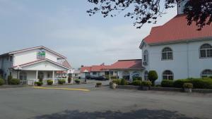 un grande edificio bianco con tetto rosso di Rainbow Motor Inn a Chilliwack