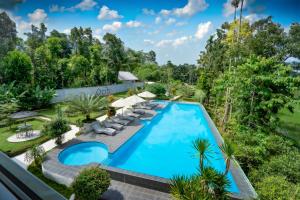 una vista sul soffitto di una piscina con sedie e alberi di Nirvana Hotel Resort Tetebatu a Tetebatu