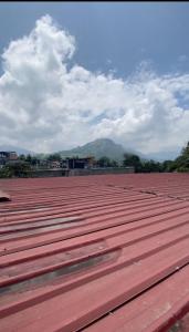 un grande tetto rosso con una montagna sullo sfondo di High Tree Nest a Badulla