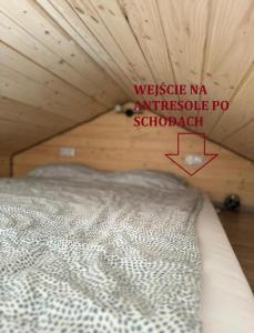 Cama en habitación con techo de madera en Domek Cud Miód en Wisła