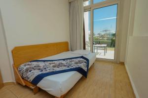 a bedroom with a bed and a large window at Andalusia Blue Beach Hurghada in Hurghada