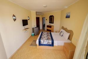 a bedroom with a bed and a television in it at Andalusia Blue Beach Hurghada in Hurghada