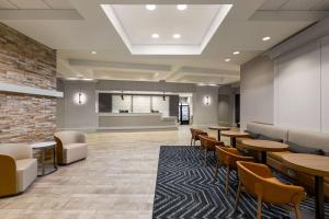 una sala d'attesa con tavoli e sedie in un edificio di Homewood Suites by Hilton Washington, D.C. Downtown a Washington