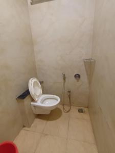 een badkamer met een wit toilet in een stal bij Hotel Lakshya Sheesh Mahal Indore in Indore