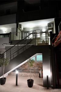 a staircase in a building with two potted trees at Casa Sym Faliraki in Faliraki