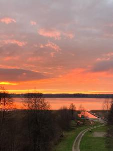 einen Sonnenuntergang über einem Wasserkörper mit einer Schotterstraße in der Unterkunft Palova Brown in Vigale